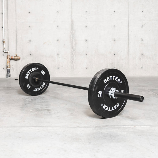 black 45 lb barbell with 45lb bumper plates and light grey barbell collar